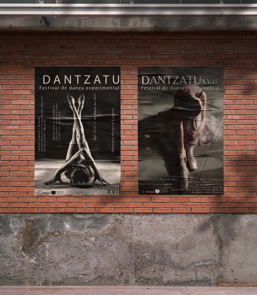 Foto de una pared en una calle de una ciudad, en esta aparecen dos de los carteles del evento